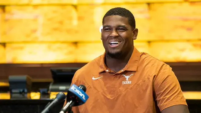 Man in Texas Shirt Smiling at a Press Conference