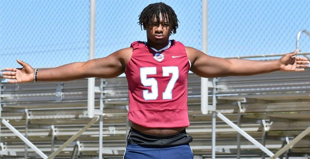 Football Player Poses with Arms Outstretched